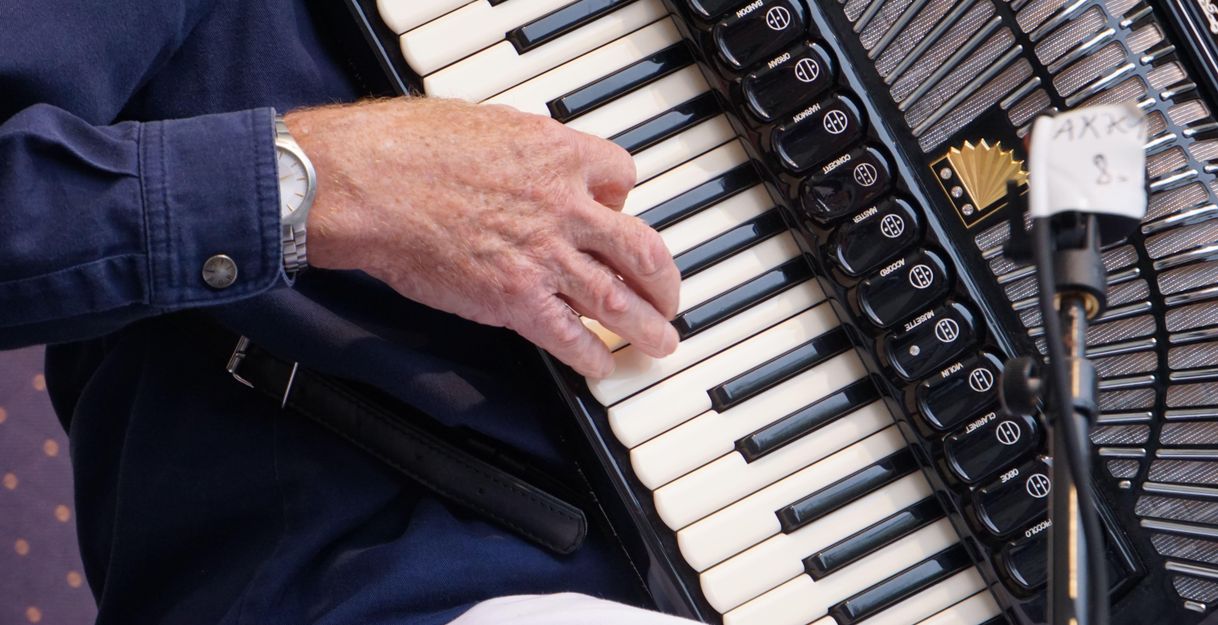 Nahaufnahme einer Hand, die ein Akkordeon spielt.