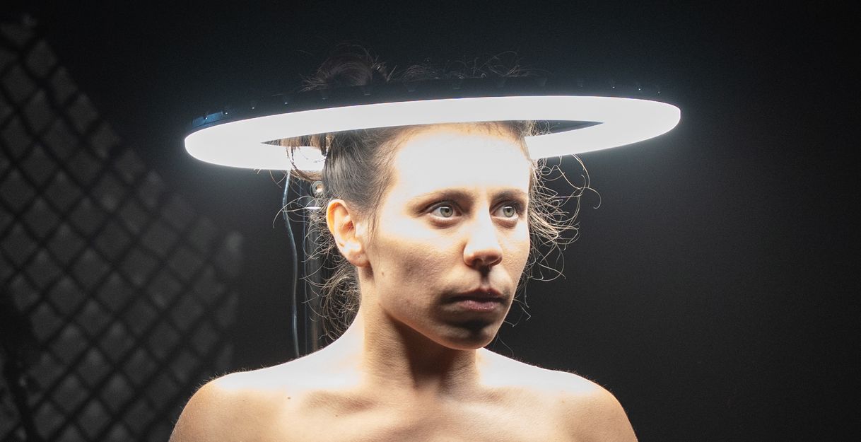 The head of a performer is surrounded by a bright circle of light.