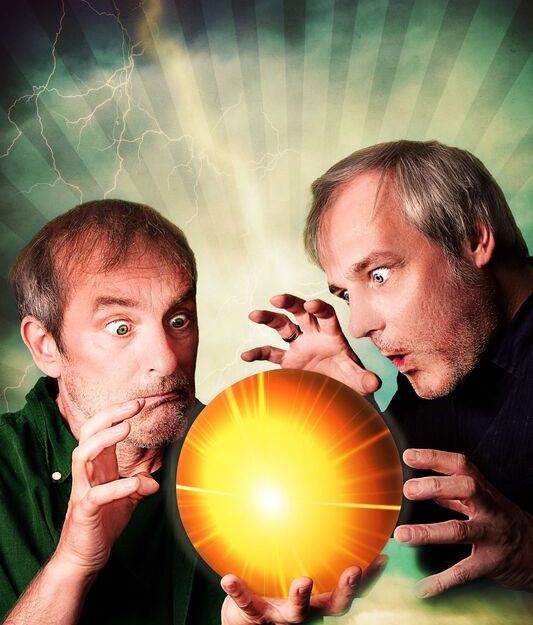 Zwei Männer blicken fasziniert auf eine leuchtende Kugel.