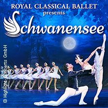 Balletttänzer in weißen Kostümen auf einer Bühne, mit einem Paar im Vordergrund in einer Hebefigur. Hintergrund mit Vollmond und Schloss.