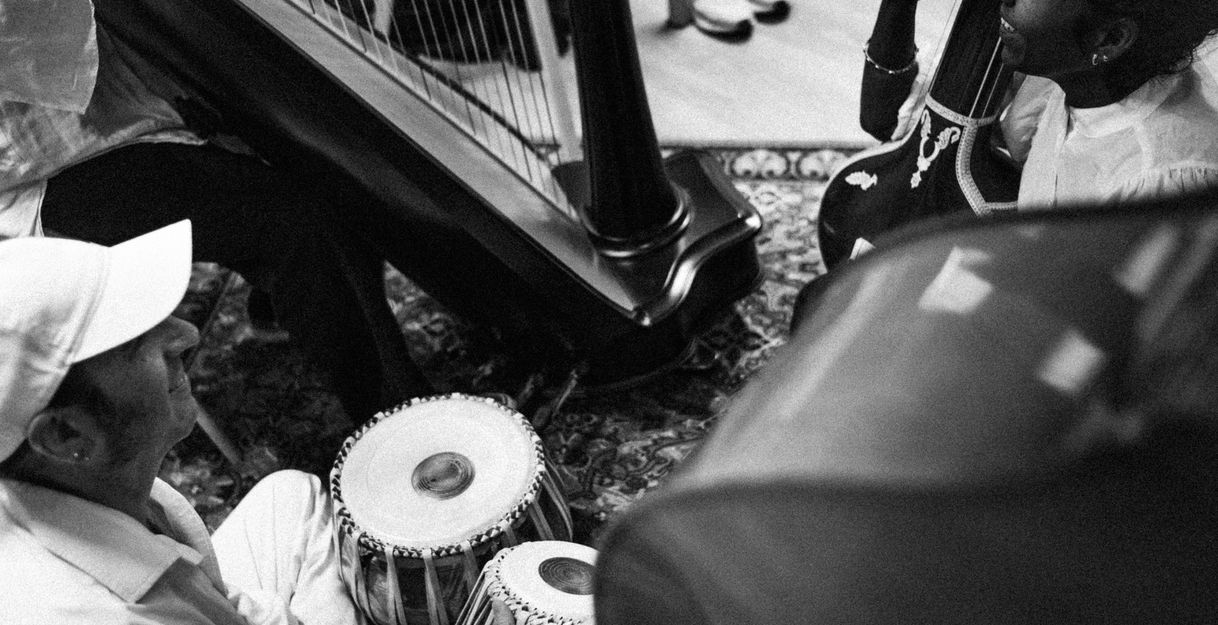 Schwarz-weiß-Foto von Musikern, die Tabla und Harfe spielen.