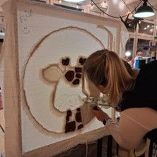 Person arbeitet an einem Tufting-Projekt mit einem Giraffenmotiv.