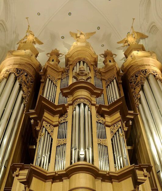 Große Kirchenorgel mit reich verzierten Holzdetails und Pfeifen.