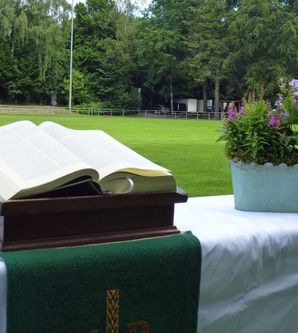 Aufgeschlagene Bibel und Blumenkorb auf einem Altar auf dem Fußballfeld