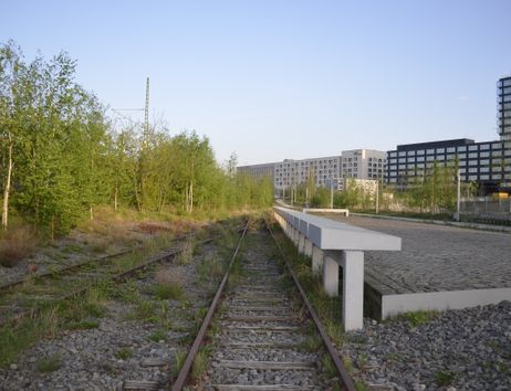 Bahngleise, daneben Gedenktafeln aus Stein