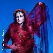 Frau in rotem Schleier vor blauem Hintergrund.