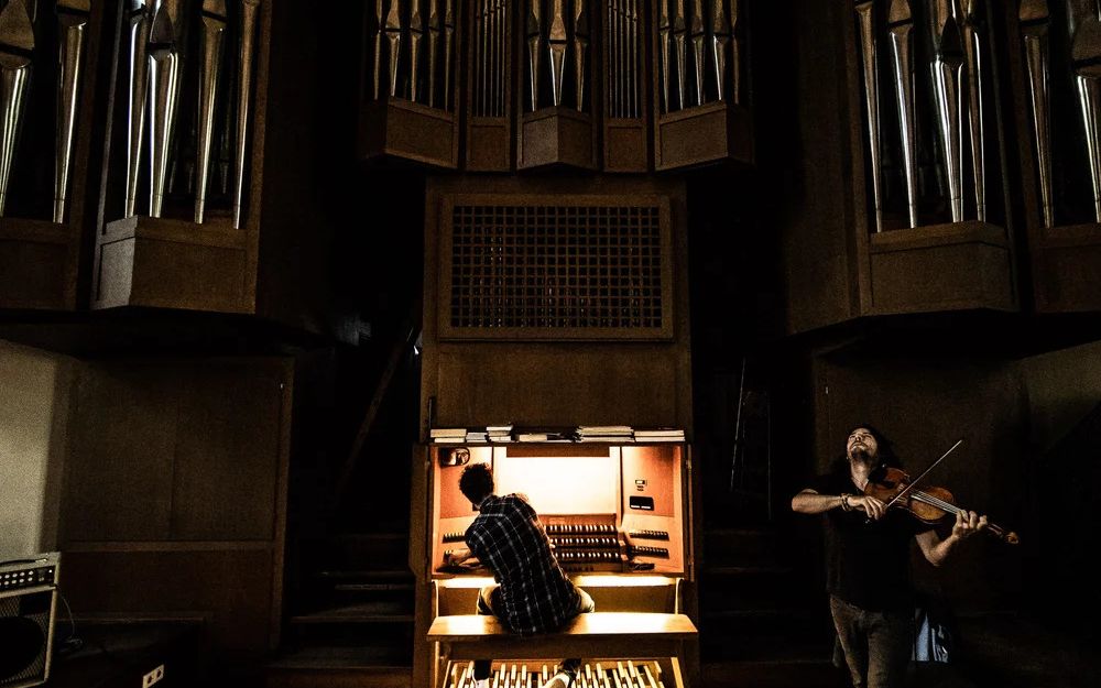 Stefan Rusconi sits at the organ, Tobias Preisig stands next to him and plays the violin.