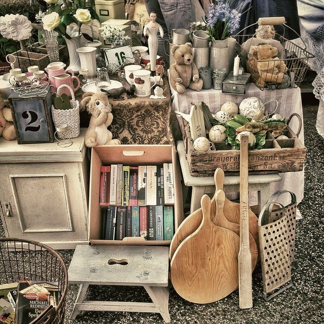 Flohmarktstand mit Büchern, Teddybären, Geschirr und Dekorationsartikeln.