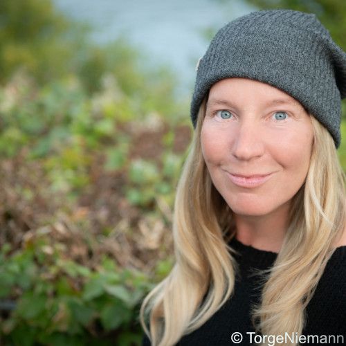 Turid Müller vor Büschen mit Mütze 