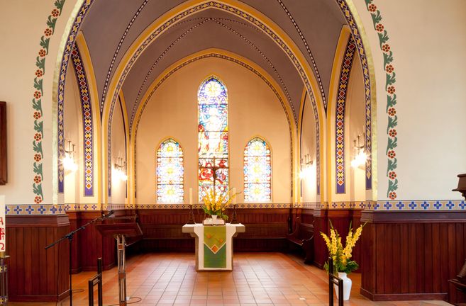 Innenansicht der Martinskirche mit Altar und bunten Glasfenstern.