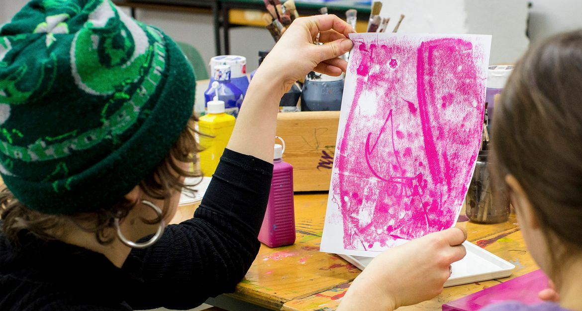 Person hält ein Kunstwerk in einem Workshop hoch.