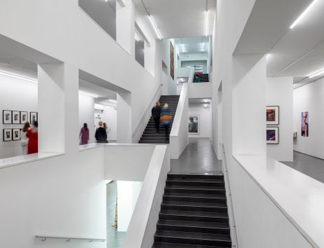 Innenansicht eines modernen Museums mit weißen Wänden und Treppen.