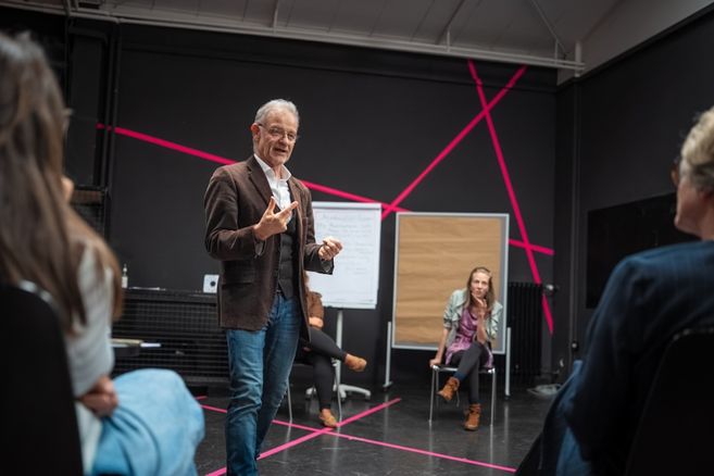 Workshopleiter Matthias Simon im Gespräch mit Teilnehmenden in einem Workshop im Scharlatan - Theater für Veränderung