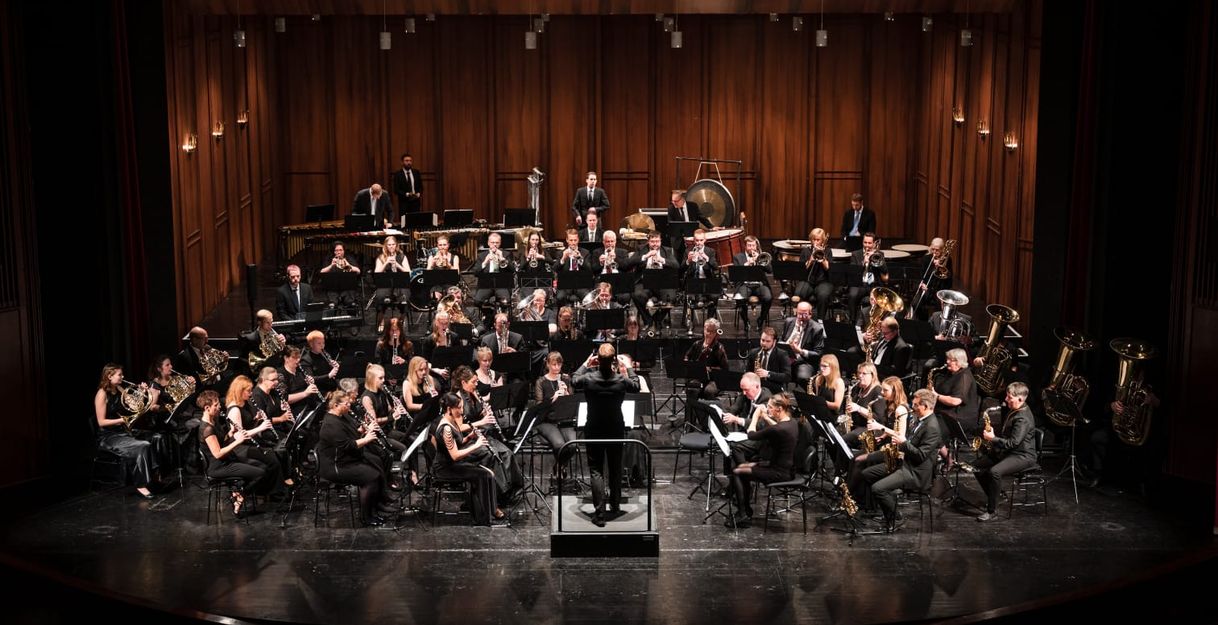 Ein Orchester spielt auf einer Bühne in einem Konzertsaal.