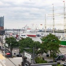 Blick auf den Hamburger Hafen mit Schiffen und der Elbphilharmonie im Hintergrund.