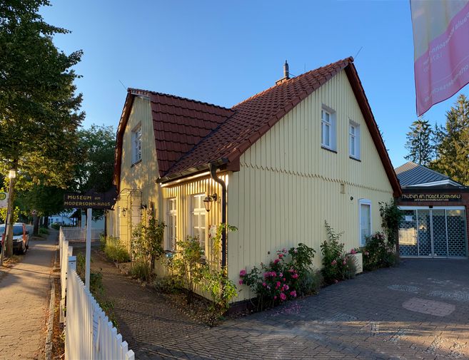 Gelbes Holzhaus mit rotem Dach, das Museum am Modersohn-Haus in Worpswede zeigt.