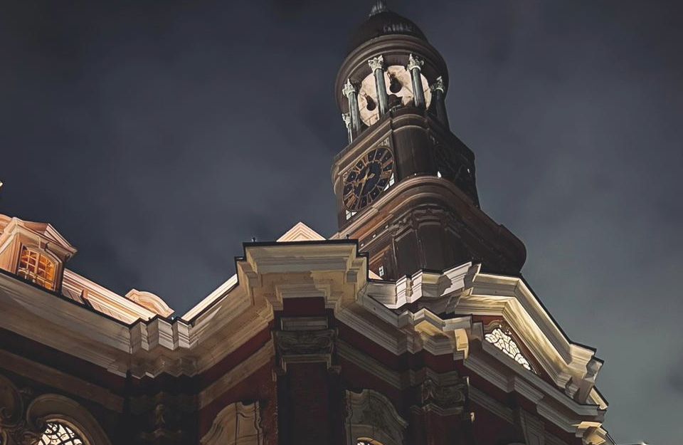Nachtaufnahme der St. Michaelis Kirche in Hamburg mit beleuchtetem Turm und dunklem Himmel.