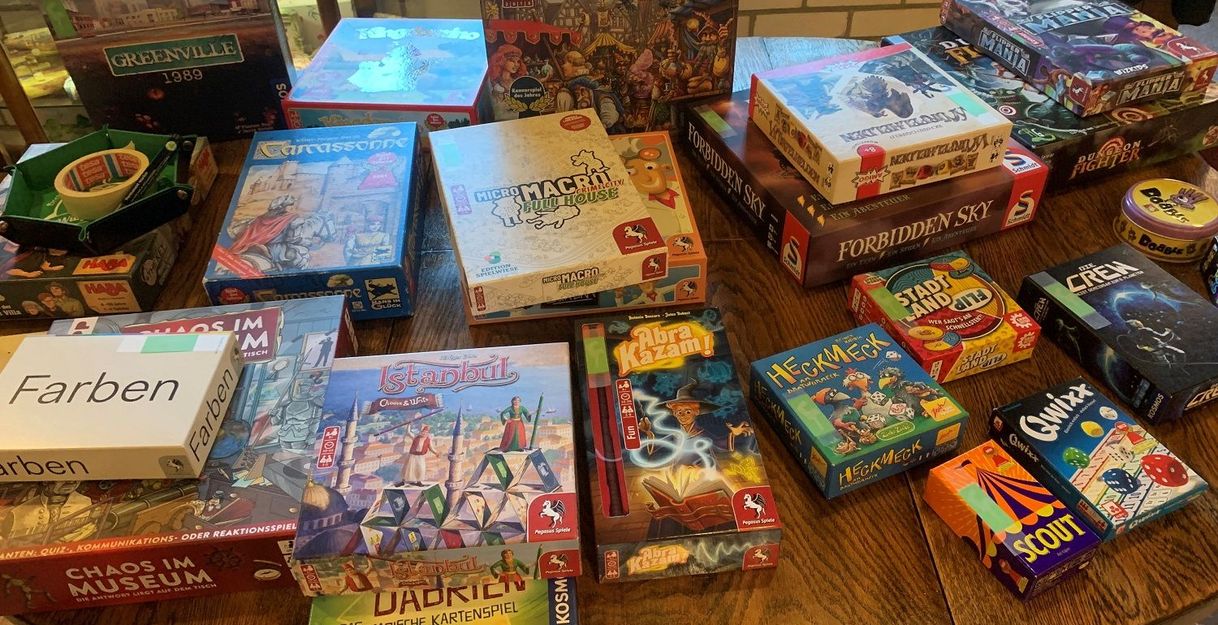 Ein Tisch voller Brettspiele, darunter Quacksalber, Carcassonne und Istanbul.