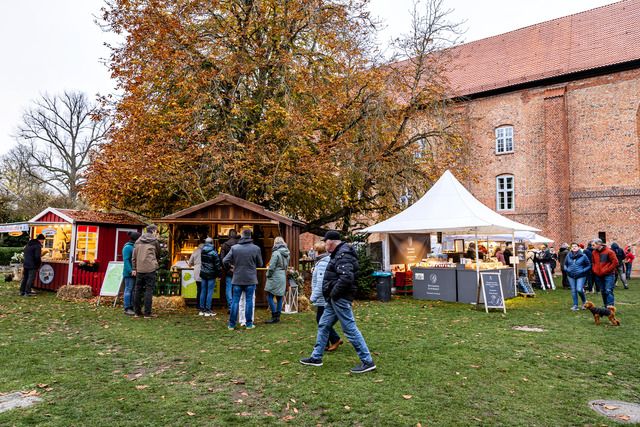 Besucher auf dem Martinsmarkt im Kloster Cismar mit Verkaufsständen und herbstlicher Kulisse.