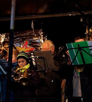 Eine Gruppe von Musikern spielt Blechblasinstrumente auf einer Bühne.