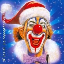 Ein fröhlicher Clown mit roter Nase und Weihnachtsmütze vor einem blauen Hintergrund mit Sternen.
