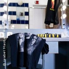 Ein Ankleidezimmer mit Nirvana-Merchandise, darunter ein T-Shirt und ein Handtuch.