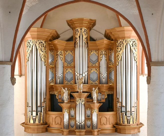 Eine große, kunstvoll verzierte Orgel mit goldenen Verzierungen und Pfeifen in einer Kirche.