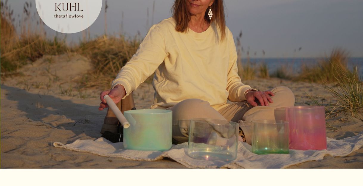 Frau sitzt im Sand und spielt Klangschalen bei Sonnenuntergang.