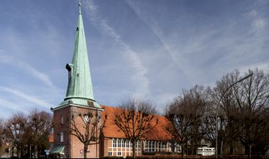 Kirche St. Johannis in Hamburg Eppendorf mit spitzem Turm und rotem Ziegeldach.