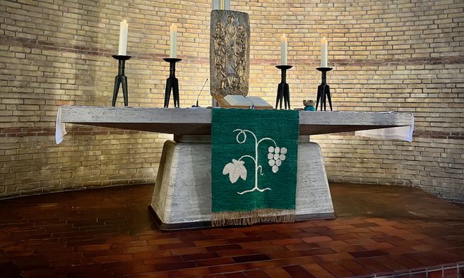 Altar in der Paul-Gerhardt-Kirche mit Kerzen und Abendmahlselementen.