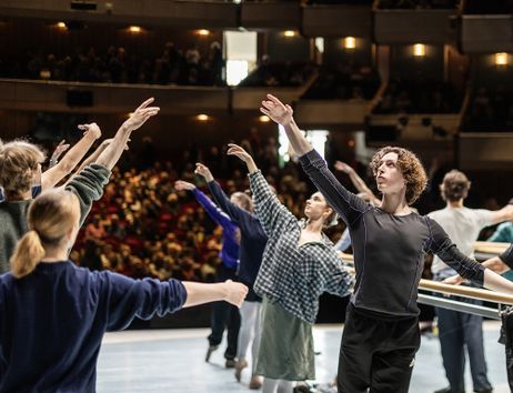 Balletttänzer üben auf einer Bühne vor Publikum.