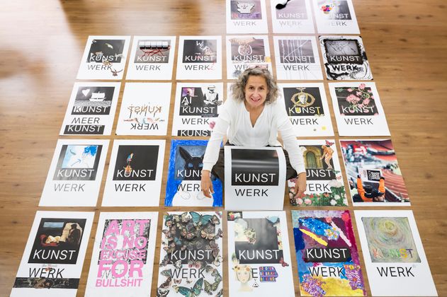Ulrike Bals mit Blanko-Plakat in mitten der Kunstwerke