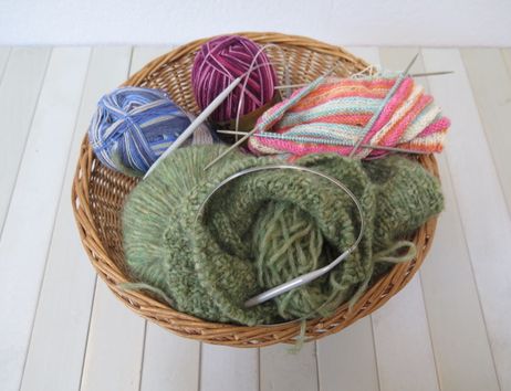 Wolle und Stricknadeln in einem Korb
