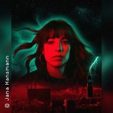 Porträt einer Frau mit rotem und grünem Lichteffekt vor einem städtischen Hintergrund mit Blitz.