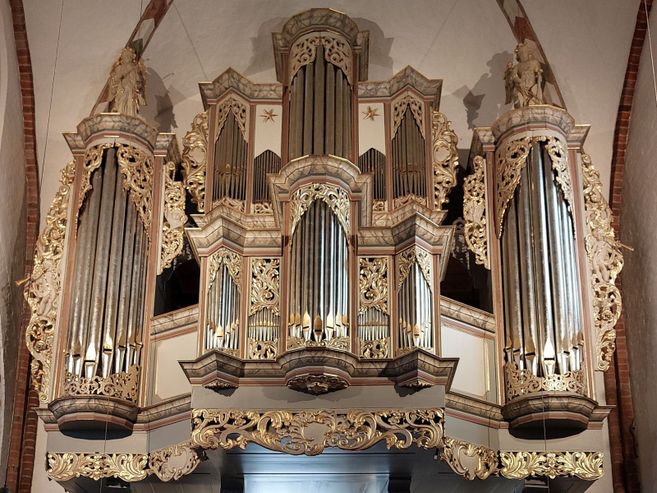 Orgel in der St. Nicolai-Kirche mit reich verzierten Pfeifen und goldenen Ornamenten.
