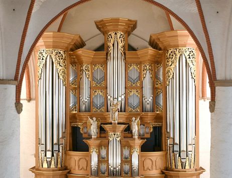 Historische Orgel mit goldenen Verzierungen und Pfeifen in einer Kirche.
