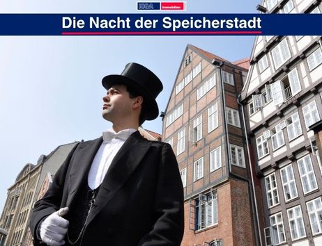 Ein Mann im Frack und Zylinder steht vor historischen Gebäuden in der Speicherstadt Hamburgs.