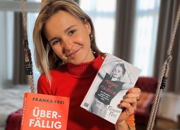 Eine Frau in rotem Pullover hält zwei Bücher von Franka Frei in den Händen.