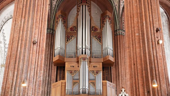 Eine große Orgel in einer Kirche mit kunstvoll verzierten Pfeifen und Holzarbeiten.