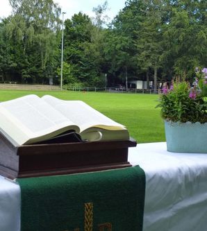 Aufgeschlagene Bibel und Blumenkorb auf einem Altar auf dem Fußballfeld