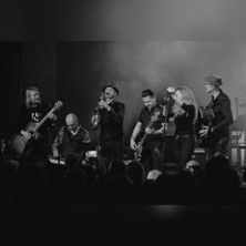 Eine Band spielt ein Konzert auf der Bühne, Musiker mit verschiedenen Instrumenten.