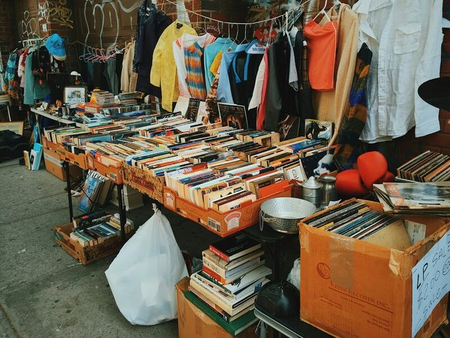 Ein Flohmarktstand mit Büchern, Kleidung und Schallplatten.