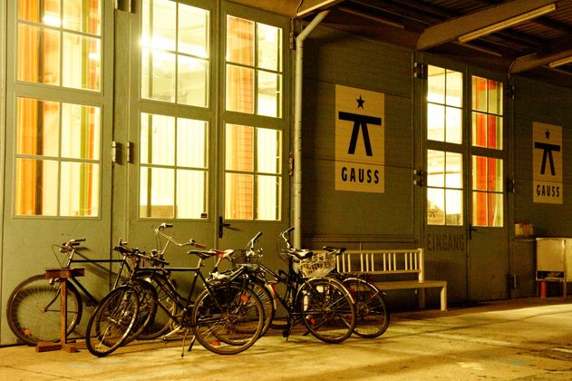 Fahrräder vor einem Gebäude mit der Aufschrift 'GAUSS'.