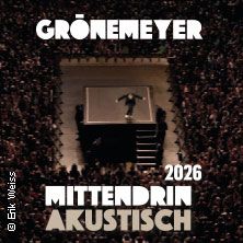 Ein Konzertfoto von oben mit einem Künstler auf einer Bühne, umgeben von einer großen Menschenmenge. Text: Grönemeyer Mittendrin Akustisch 2026.