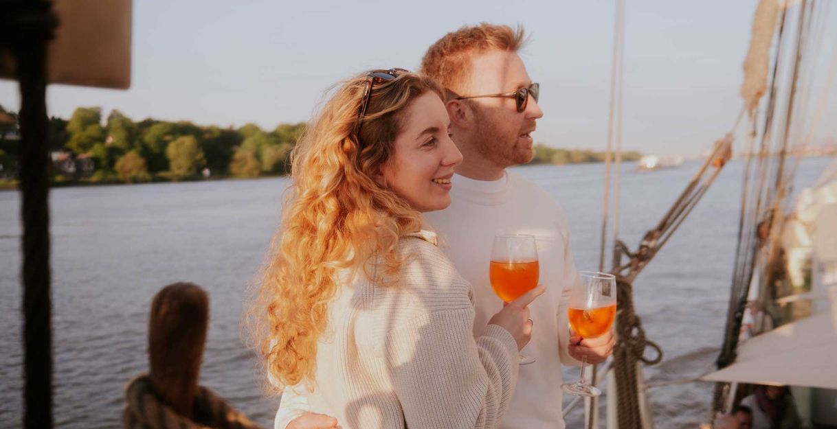 Ein Pärchen mit Aperol in der Hand an Deck des Segelschiffes Mare Frisium.