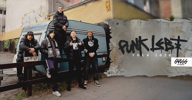 Fünf Personen posieren vor einem Wohnwagen mit Graffiti im Hintergrund. Rechts im Bild steht "Punk lebt Tour 2026".