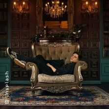 Person entspannt auf einem luxuriösen Sessel in einem elegant dekorierten Raum.