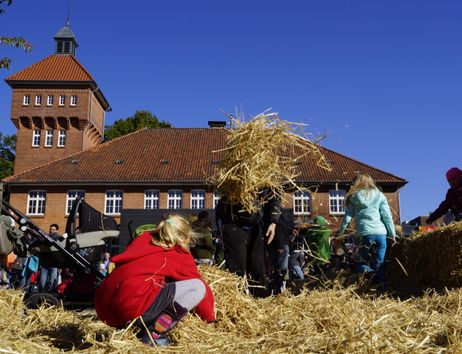 Kinder spielen auf einer Strohballenburg auf dem Alsterdorfer Markt.