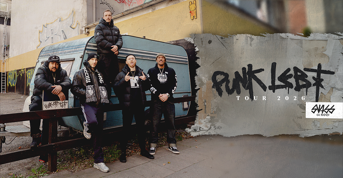 Fünf Personen posieren vor einem Wohnwagen mit Graffiti im Hintergrund. Rechts im Bild steht "Punk lebt Tour 2026".