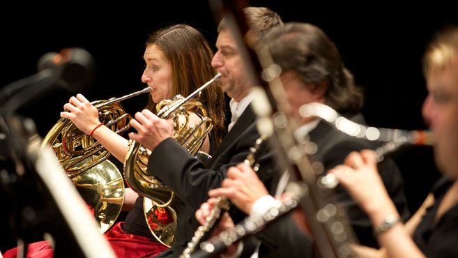 Musiker eines Orchesters spielen Blechblasinstrumente während eines Konzerts.